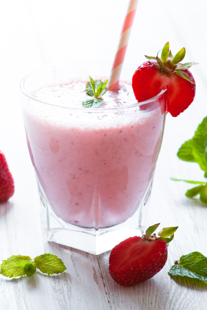 Milkshake. Milkshake with fresh strawberries in a glass jar on white. dairy drink.の写真素材