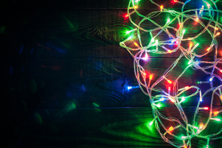 Christmas colorful lights over wooden background. Top view with copy spaceの写真素材