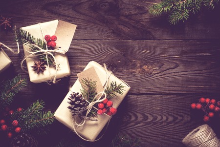 Packing Christmas gifts. Christmas gift boxes and decorations on wooden table. Top view with copy spaceの写真素材