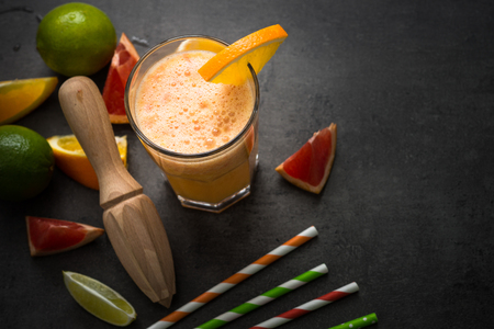 Citrus drink. Fresh citrus smoothie juice at dark background. Top view with copy spaceの写真素材