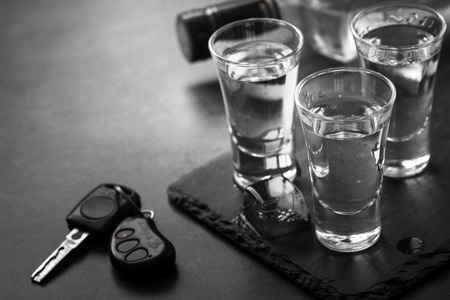 Vodka shot drink and car key. Don't drink and drive concept. Monochrome.の写真素材