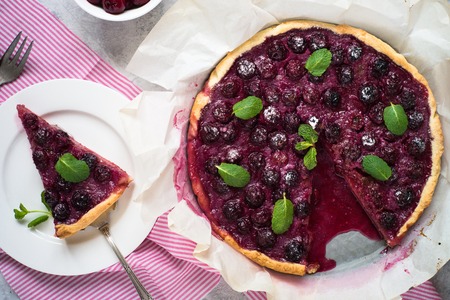 Sweet cherry cake pie tart. Summer dessert. Top view. Grey Concrete table