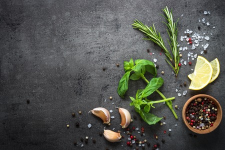 Selection of spices herbs and greens. Ingredients for cooking. Food background on black slate table. Top view copy space.の写真素材