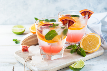Homemade lemonade  from different citrus. Refreshing summer drink with ice on light background.の写真素材