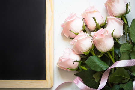 Pink rose at white  table. Top view copy space. Flower background.の写真素材