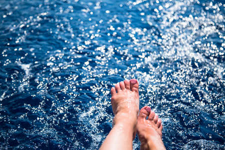 Female enjoy sea. female legs in the blue sea water. Happiness lifestyle summer vacation.の写真素材