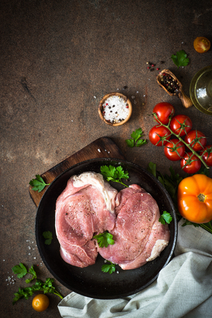Raw pork meat in the pan. Ready for cooking. Fresh Meat steak. Top view copy space on rusty stone table.の写真素材