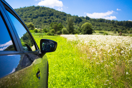 Black car in the grass on the nature. Summer trip Car off-road travel concept.の写真素材