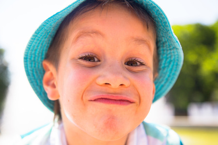 Happy child outdoor. Little boy with funny face in th park.の写真素材