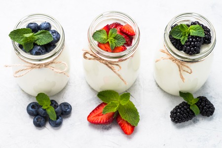 Fresh homemade yogurt with berries in glass jars. Healthy food. Dairy products.の写真素材