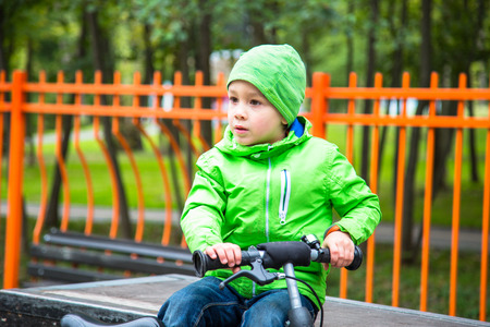 Little kid boy outdoor in park with bike.の写真素材