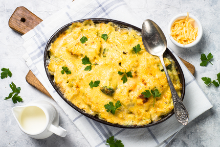 Gratin or Casserole from fish, pasta, broccoli and cheese in bechamel sause. Top view on gray stone table.の写真素材