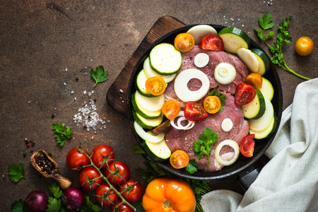 Raw pork meat with vegetables in the pan.の写真素材