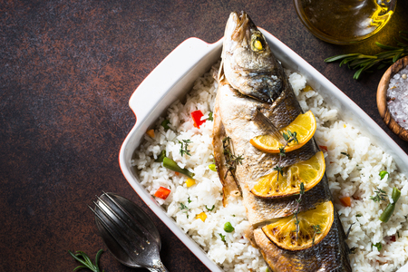 Fish seabass baked with rice and vegetables.の写真素材
