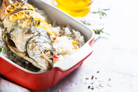 Fish seabass baked with rice and vegetables.の写真素材