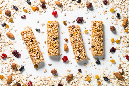 Granola bar. Healthy sweet dessert snack. Cereal granola bar with nuts, fruit and berries on a white stone table. Top view.の写真素材