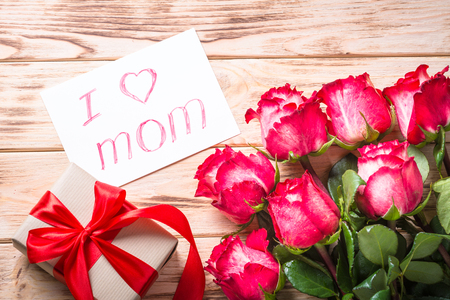 Red rose flower and present box on wooden table.の写真素材