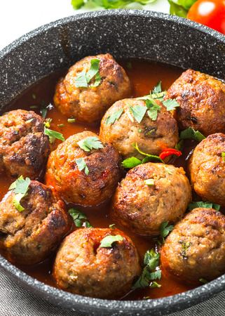 Meat balls in tomato sauce in a frying pan.の写真素材