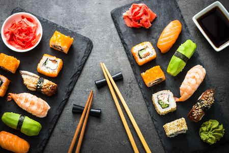 Sushi and sushi roll set on black stone table top viewの写真素材