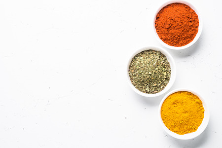 Various spices in a bowls on white background. Red green and yellow spices. Top view.の写真素材