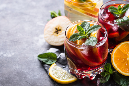 Sangria with fruit, ice and mint in glass. Summer alcohol drink and ingredients.の写真素材