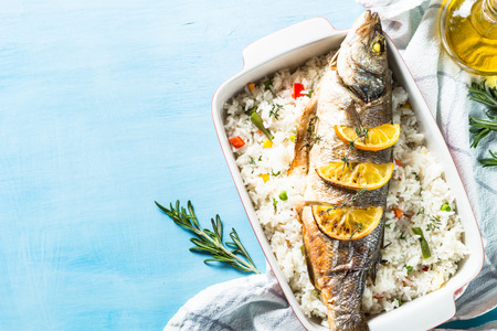 Fish seabass baked with rice and vegetables.の写真素材