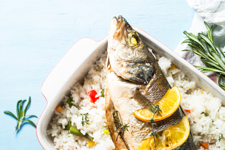 Fish seabass baked with rice and vegetables.の写真素材