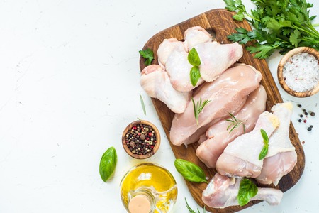 Chicken meat assortment. Chicken fillet, breast, wings and drumsticks. White table top view with copy space.の写真素材