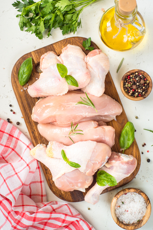 Chicken meat assortment. Chicken fillet, breast, wings and drumsticks. White table top view.の写真素材