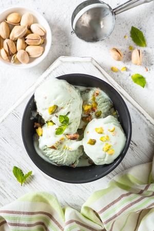 Pistachios ice cream in bowl on white stone table.の写真素材