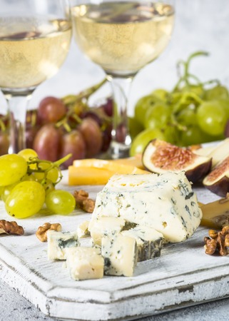 Cheese plate with grapes, figs and nuts. Wine snaks. Cheese assortment.の写真素材