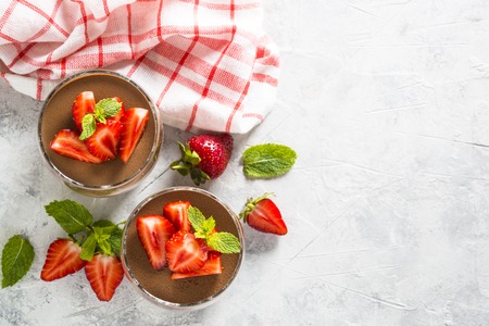 Chocolate dessert of whipped cream and strawberries in glass.の写真素材