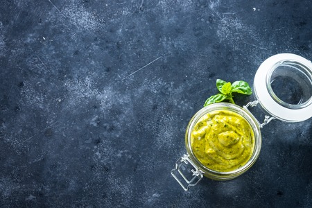 Pesto sauce. Basil, olive oil, pine nuts, parmesan and garlic on black stone table.の写真素材