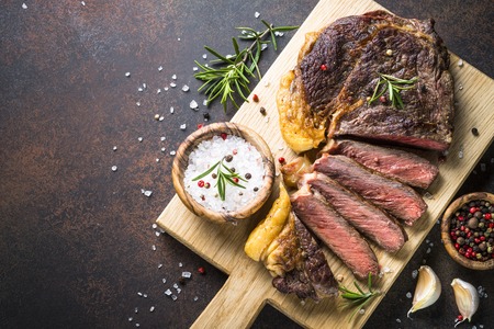 Grilled beef steak ribeye on wooden cutting board.の写真素材