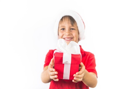 Child boy in christmas Santa hat and red present box on white.の写真素材