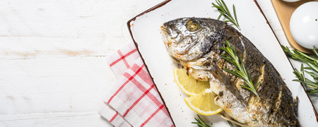 Baked dorado fish with lemon and rosemary top view.の写真素材