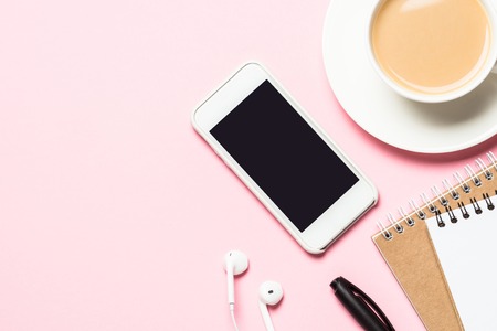 Female home office  workplace with notepad, coffee cup, succulent and mouse on pinkの写真素材