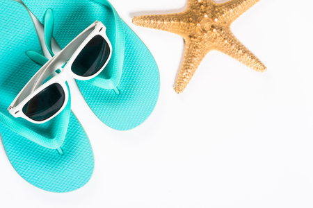 Blue flip flops, sunglasses and starfish on blue background.の写真素材