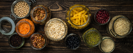 Cereals, Legumes, and beans in glass jars on  dark wooden table.の写真素材