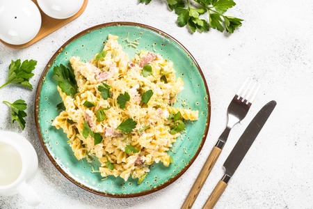 Pasta carbonara with zucchini in craft plate on white.の写真素材