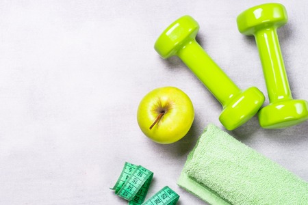 Dumbbells, measuring tape, water and apple top view.の写真素材