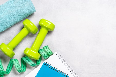 Dumbbells, measuring tape, water and apple top view.の写真素材