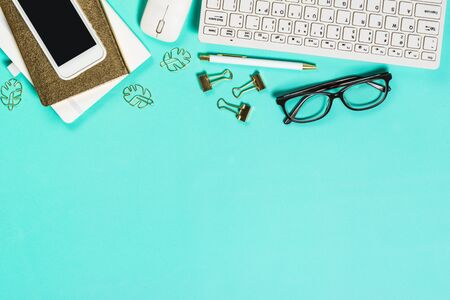 Office workplace with keyboard, notepad, glasses and pen