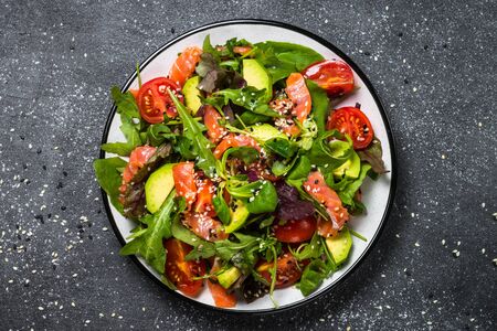 Salmon salad with fresh vegetables on black top view.の写真素材