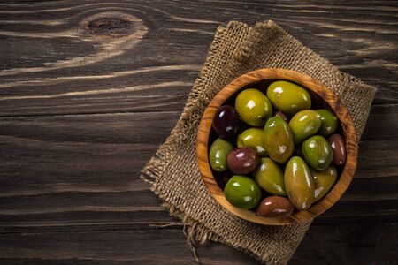 Black and green olives on wooden table.の写真素材