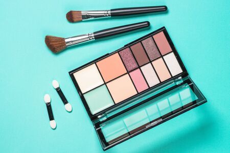 Eyeshadows and brushes at mint background.の写真素材