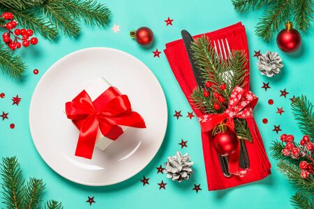 Christmas table setting with white plate, silverware and xmas decorations. Top view.の写真素材