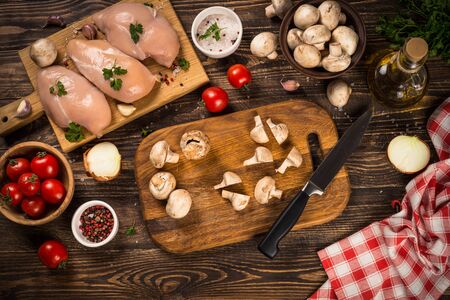 Chicken fillet with ingredients for cooking on dark wooden kitchen table. Top view with copy space.の写真素材