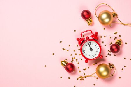 Christmas flat lay background with red clock and decor on pink.