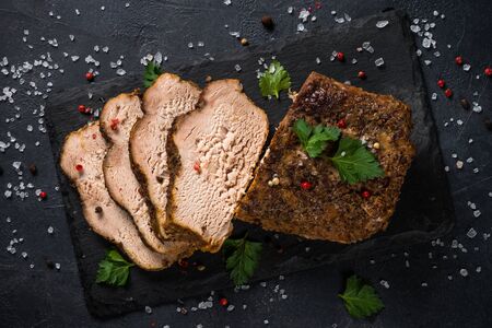Baked pork meat ham on black kitchen table.の写真素材